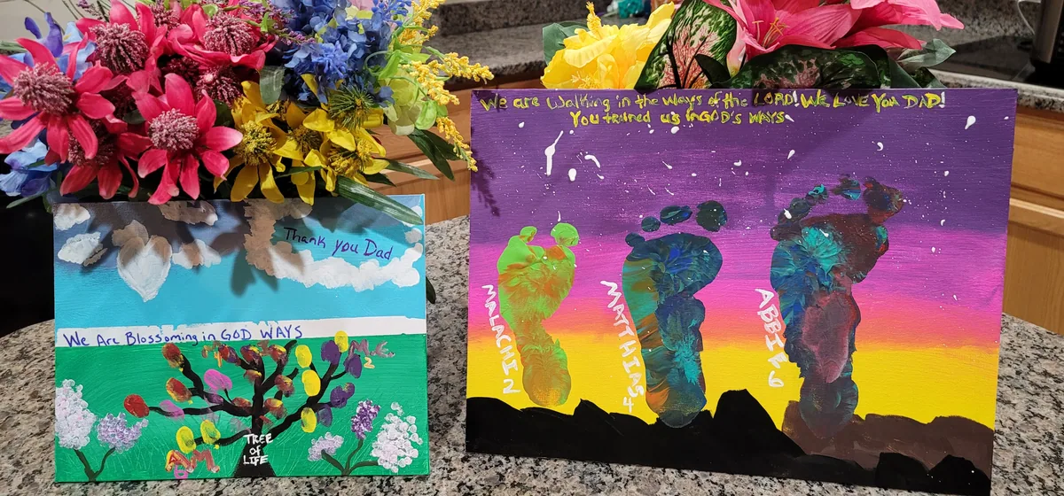 Father's Day art: footprint silhouettes labelled with the children's names against a painted sunset