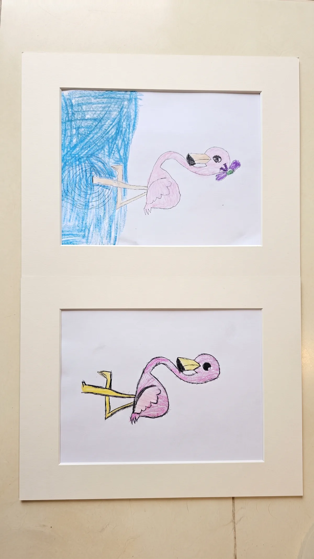 Two pink-flamingo drawings in pencil and crayon on white paper