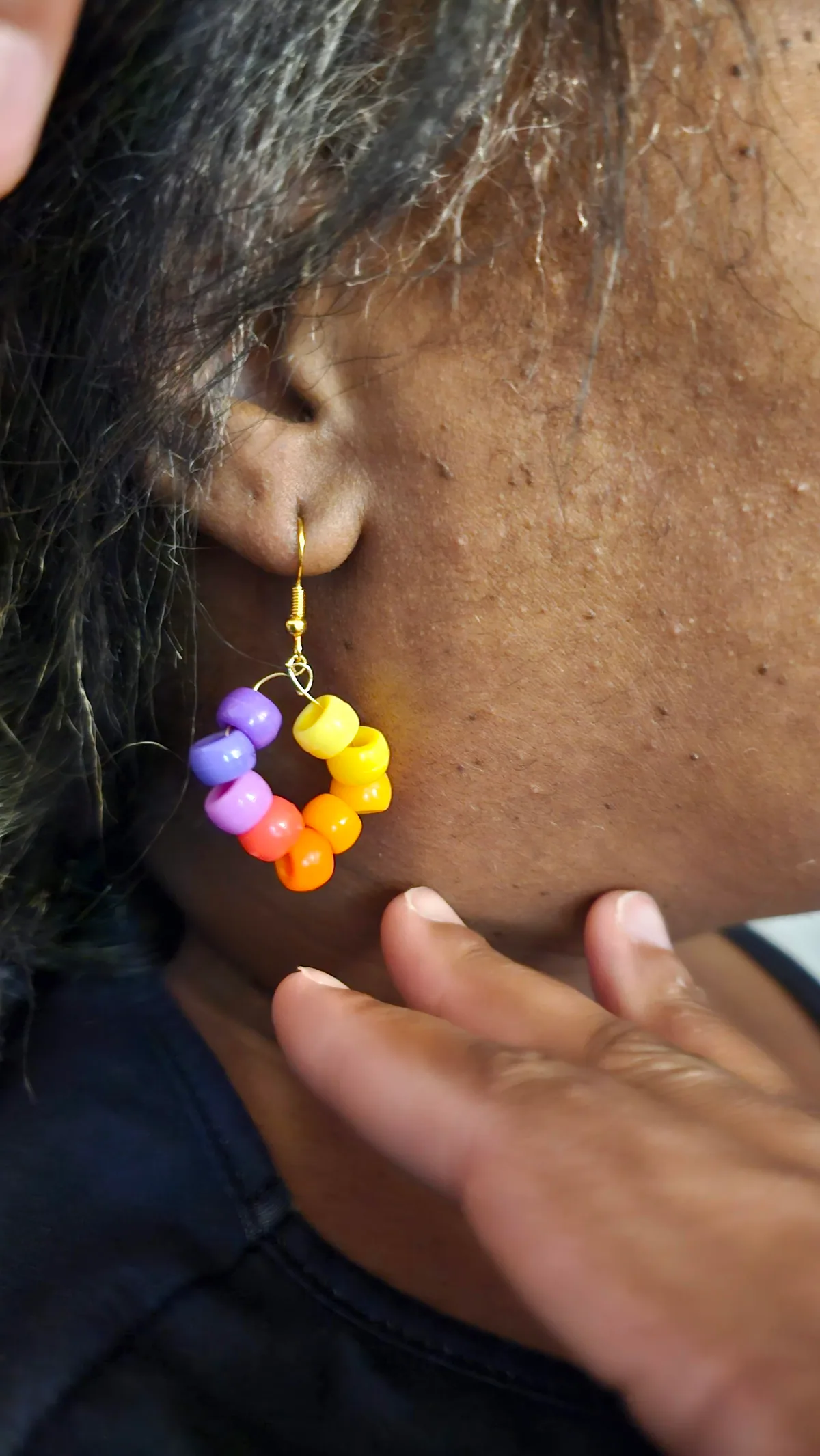 Handmade bead-and-wire earring photographed on the ear