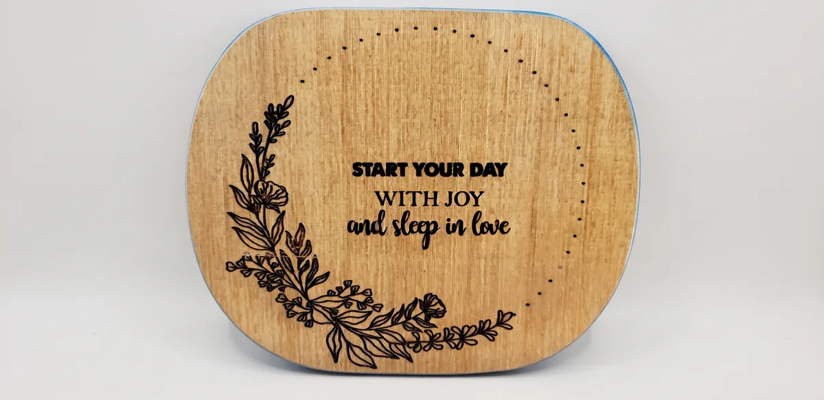 Laser-engraved wood plaque with botanical wreath and the words "Start your day with joy and sleep in love"